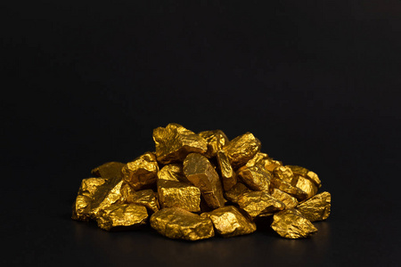 黑色矿石一堆金块或金矿石上的黑色背景宝石或一块金石金融和商业概念