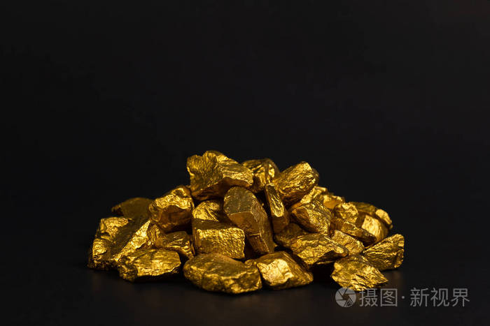 一堆金块或金矿石上的黑色背景宝石或一块金石金融和商业概念.