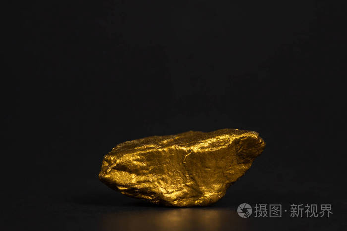 在黑色背景宝石或金石上特写金块或金矿石的财务和商业理念