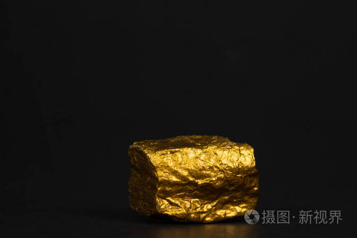 在黑色背景宝石或金石上特写金块或金矿石的财务和商业理念