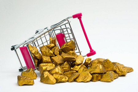 一堆金块或金矿石在购物车或超市手推车上的白色背景宝石或块金石金融和商业理念。