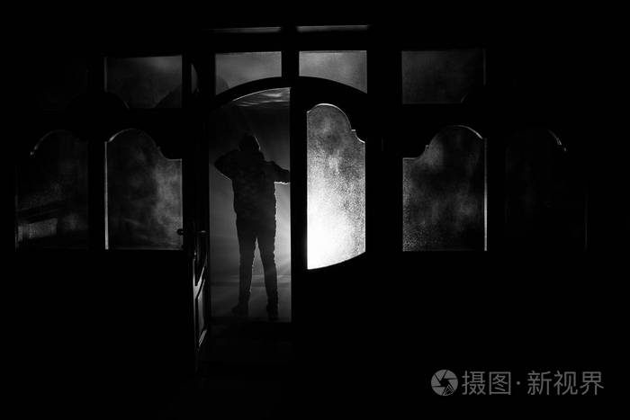 一个未知的影子在一扇门上的轮廓通过一扇封闭的玻璃门.