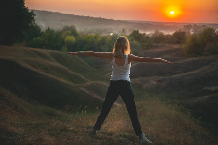 年轻女子在日落时练习瑜伽