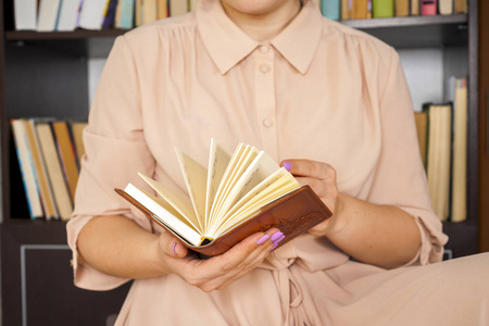 穿着浅色衣服的年轻女孩在老式大学图书馆里选择书, 看书和放松