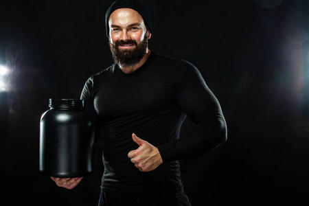 快乐和健康的肌肉年轻健身运动男子与一罐运动营养蛋白质, 增益和酪蛋白