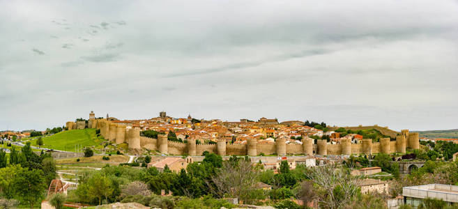 全景的历史城市阿维拉西班牙与其著名的中世纪城镇墙周围的城市日落。 联合国教科文组织世界遗产。 被称为石头和圣徒之城