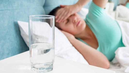 水玻璃特写图像旁边的病妇女头痛