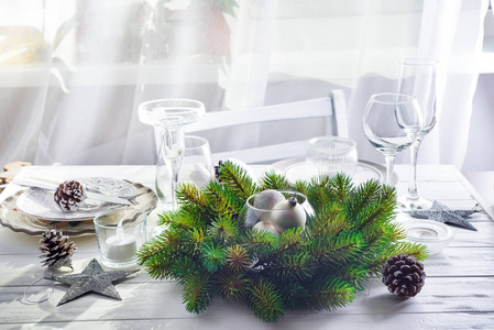 圣诞节花圈与玩具在桌与银色圣诞节桌设置与圣诞节装饰在轻的窗口之上