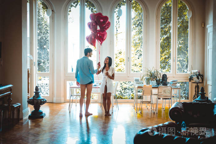 在家的浪漫时刻，男友向女友展示心形气球
