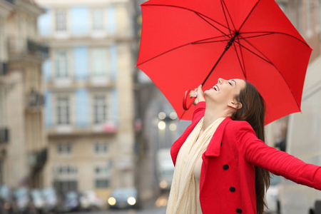 3.自发的女人在冬天的雨中撑着红伞庆祝成功