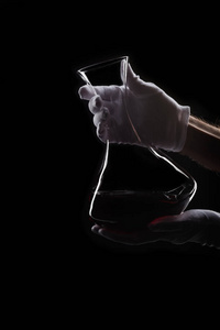 戴白手套的人拿着酒瓶喝红酒照片