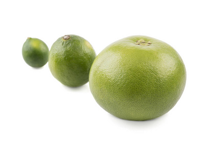 一个大的绿色全葡萄柚和两个石灰分离在白色背景上。 富含维生素的柑橘类水果的概念
