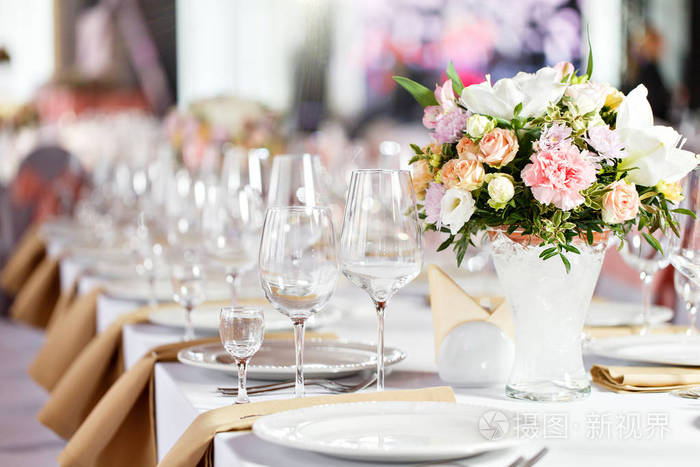 桌上的豪华婚礼招待会。桌子上有美丽的花朵。上菜, 玻璃杯, 服务员工作