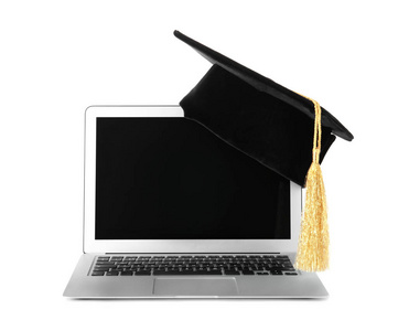 毕业帽与金色流苏和笔记本电脑隔离在白色。 文本空间