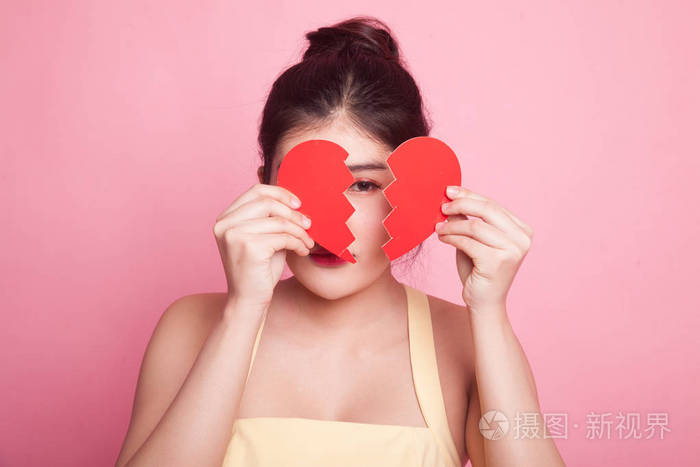 美丽的年轻亚洲女人心碎的粉红色背景
