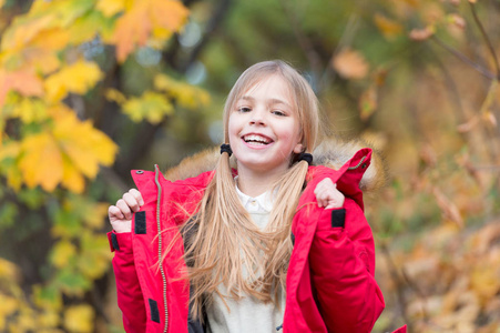 充满了生命的能量。小女孩穿大衣的秋天季节自然背景。孩子在秋天散步愉快。暖和的大衣是秋天最好的选择。保持身体暖和的衣服秋天的日子。