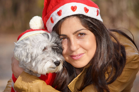 美丽的年轻黑发女人带着她的狗享受圣诞节或新年