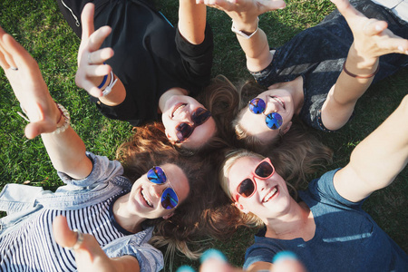 时尚的女孩躺在公园的草地上,毫无概念的青年和学生旅游和度假照片