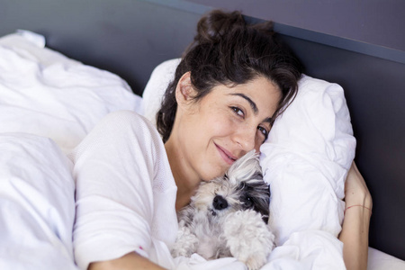 女人抱着睡狗躺在床上