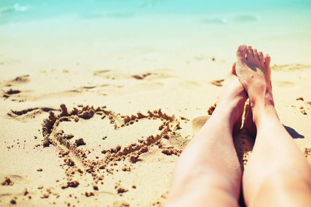 在沙滩上躺在沙滩上的女性腿