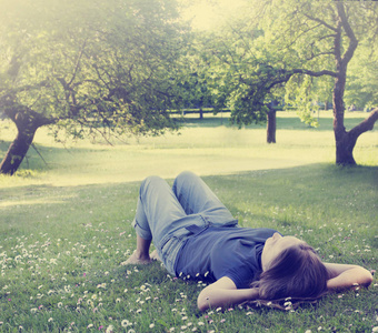 女人躺在草地上,开着雏菊照片