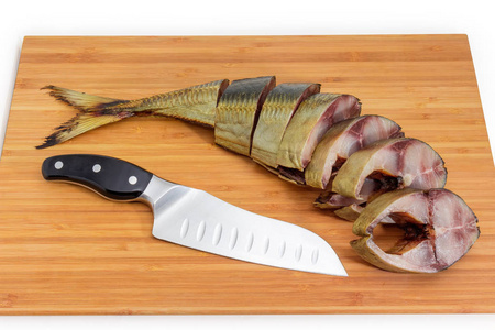 白色背景的木竹砧板上没有头和菜刀的切片烟熏大西洋鲭鱼