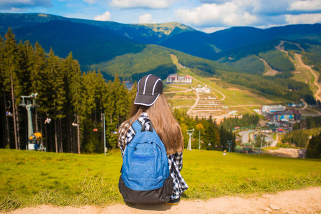 后景的徒步旅行者妇女与背包在山顶。旅行概念。