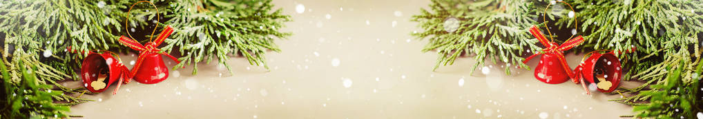 圣诞节背景有圣诞节的冷杉枝和红铃在雪的气氛。圣诞横幅。划形象，降雪效果..