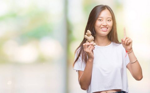 年轻的亚洲女性，在孤立的背景下，手握新鲜的有机食品，惊讶地发现自己的想法或问题，手指着幸福的面孔，头号人物