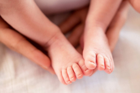 在慈爱的母亲手中特写柔软的婴儿双脚