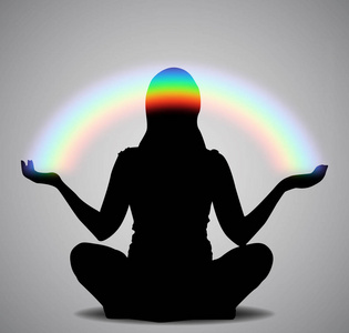 黑色轮廓的女孩坐在莲花姿态的灰色背景与彩虹照片