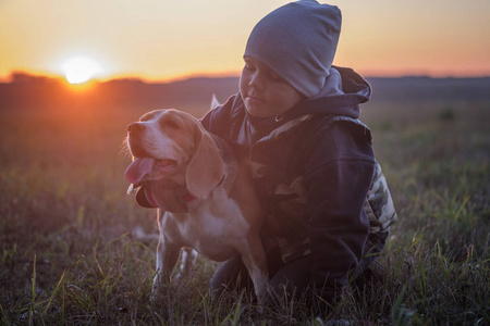 欧洲男孩和狗猎犬在秋日傍晚散步