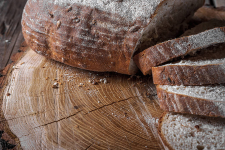 木切割板上的切片面包和刀。 木制乡村背景