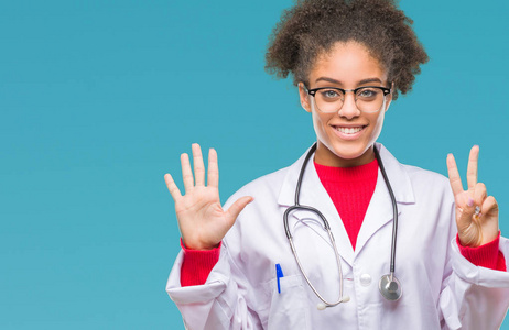 年轻的AFRO美国医生妇女在孤立的背景显示和指向7号手指，同时微笑自信和快乐。