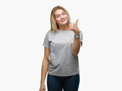 年轻的高加索女人在孤立的背景下，用手做快乐的竖起大拇指的手势。 赞许的表情看着相机，显示出成功。