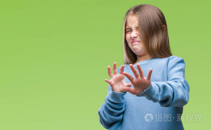 年轻漂亮的女孩穿着冬天的毛衣,在孤立的背景下,厌恶的表情,不高兴和