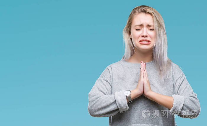 年轻的金发女人在孤立的背景下乞讨和祈祷双手和希望的表情在脸上非常