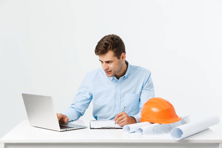 专注于认真勤奋的工程师忙于在大型建筑项目工作后期, 坐在他的工作区