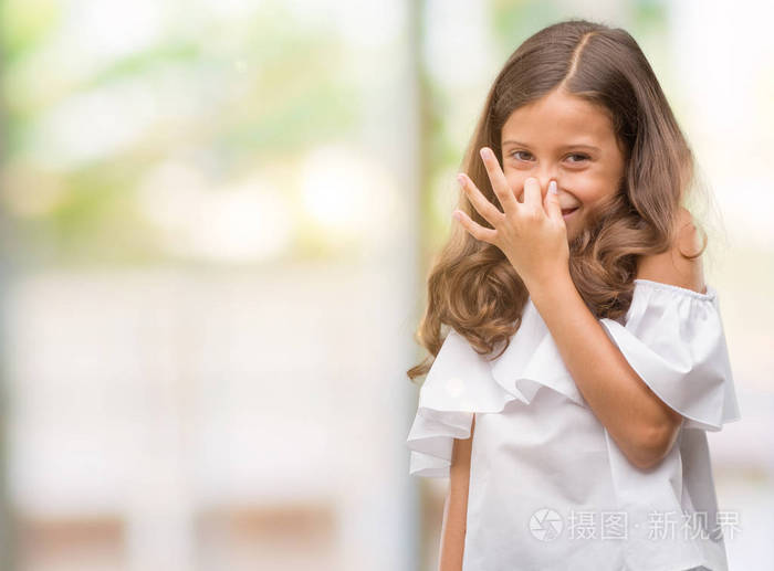 黑发西班牙女孩闻着一些臭味和令人恶心的难以忍受的气味屏住呼吸