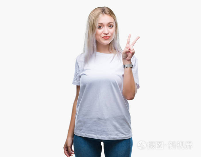 年轻的金发女子在孤立的背景显示和指着第二个手指同时微笑自信和快乐