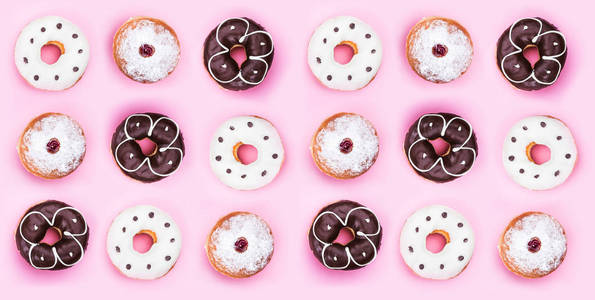 收集各种五颜六色的甜甜圈从上面孤立在粉红色背景水平视图。