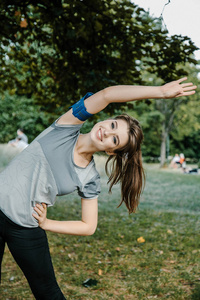 一个年轻漂亮的女孩做户外运动。在公园里, 女孩进行体育锻炼。