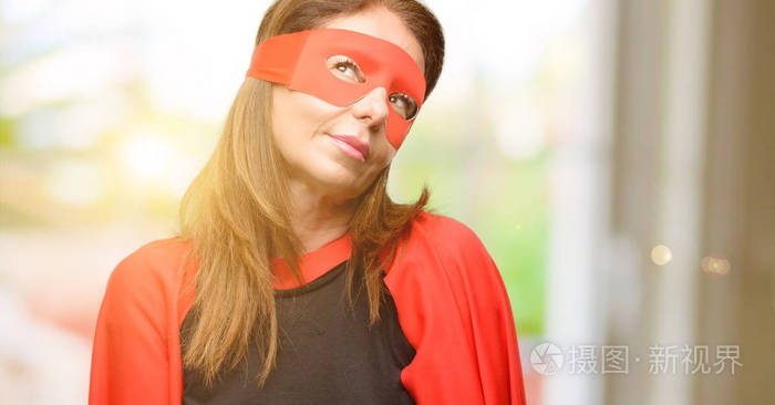 中年超级英雄女人戴着红色面具，披着斗篷，思考着，仰望着，表达着怀疑和惊奇