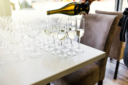 站成一排在供应桌子的香槟优雅眼镜