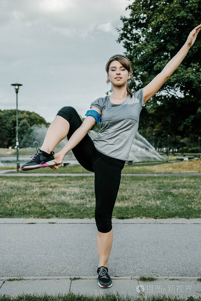 一个年轻漂亮的女孩做户外运动.在公园里, 女孩进行体育锻炼.