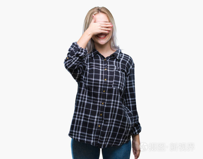 年轻的金发女人在孤立的背景上微笑和笑,用手捂着眼睛,以求惊喜.
