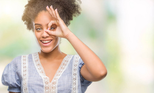 年轻的非洲美国妇女在孤立的背景下做好手势，用手微笑的眼睛透过手指看着快乐的脸。