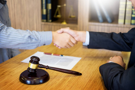当事人在法庭律师服务理念的背景下,法官和当事人在木桌上握手照片