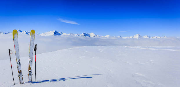 滑雪在冬季季节，高山和滑雪旅游设备在顶部在阳光明媚的一天，法国阿尔卑斯山在云层之上