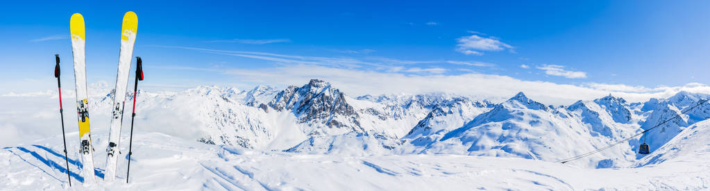 滑雪在冬季季节，高山和滑雪旅游设备在顶部在阳光明媚的一天，法国阿尔卑斯山在云层之上
